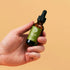A hand holding the Berodin Post Wax Essential Oil